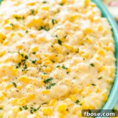 Slow Cooked Cheesy Corn Comfort 6 Close up photo of a teal serving dish filled with cheesy corn.