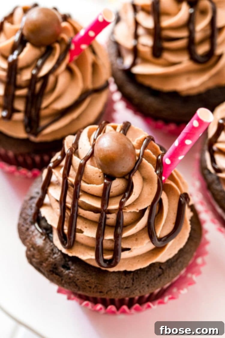 A close-up, artfully angled shot of freshly baked chocolate milkshake cupcakes, showcasing their perfectly piped frosting and inviting texture, arranged on an elegant cake stand.