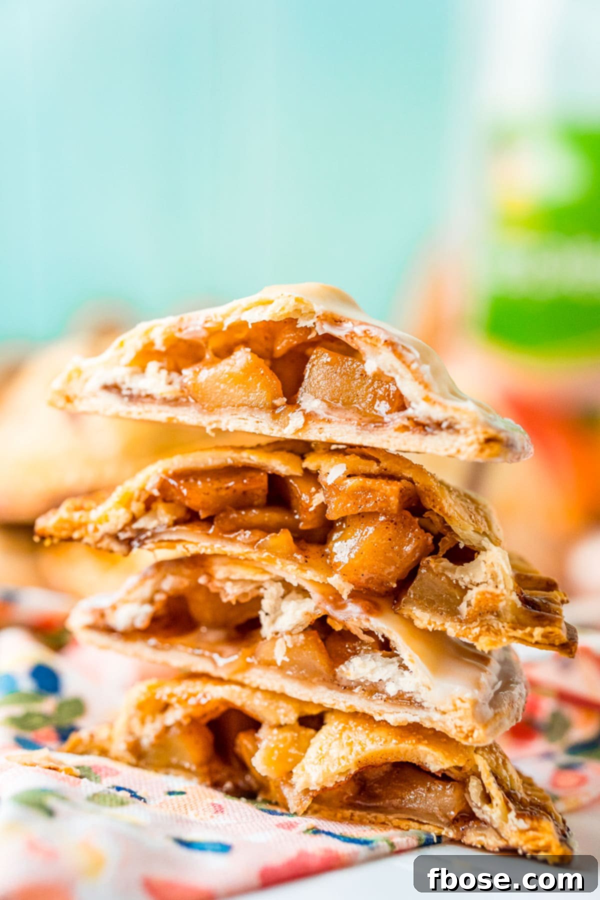 Golden Apple Hand Pies 6 A stack of apple hand pies that have been cut in half.