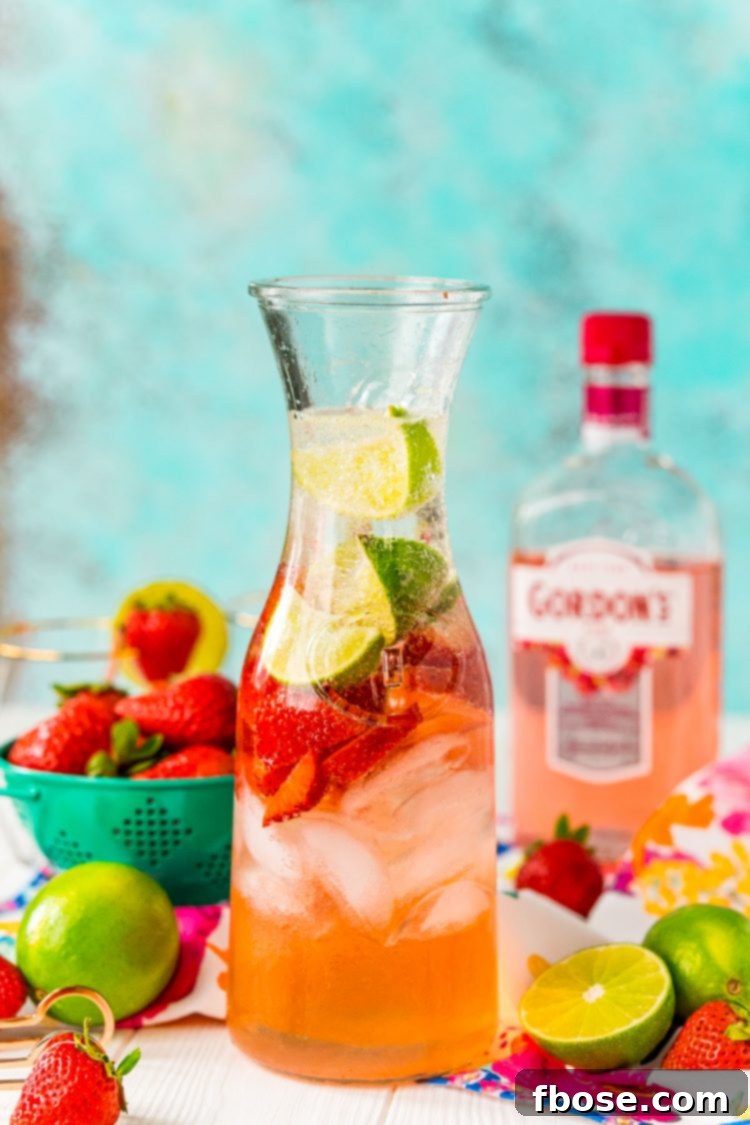 A carafe filled with a fruity pink cocktail.