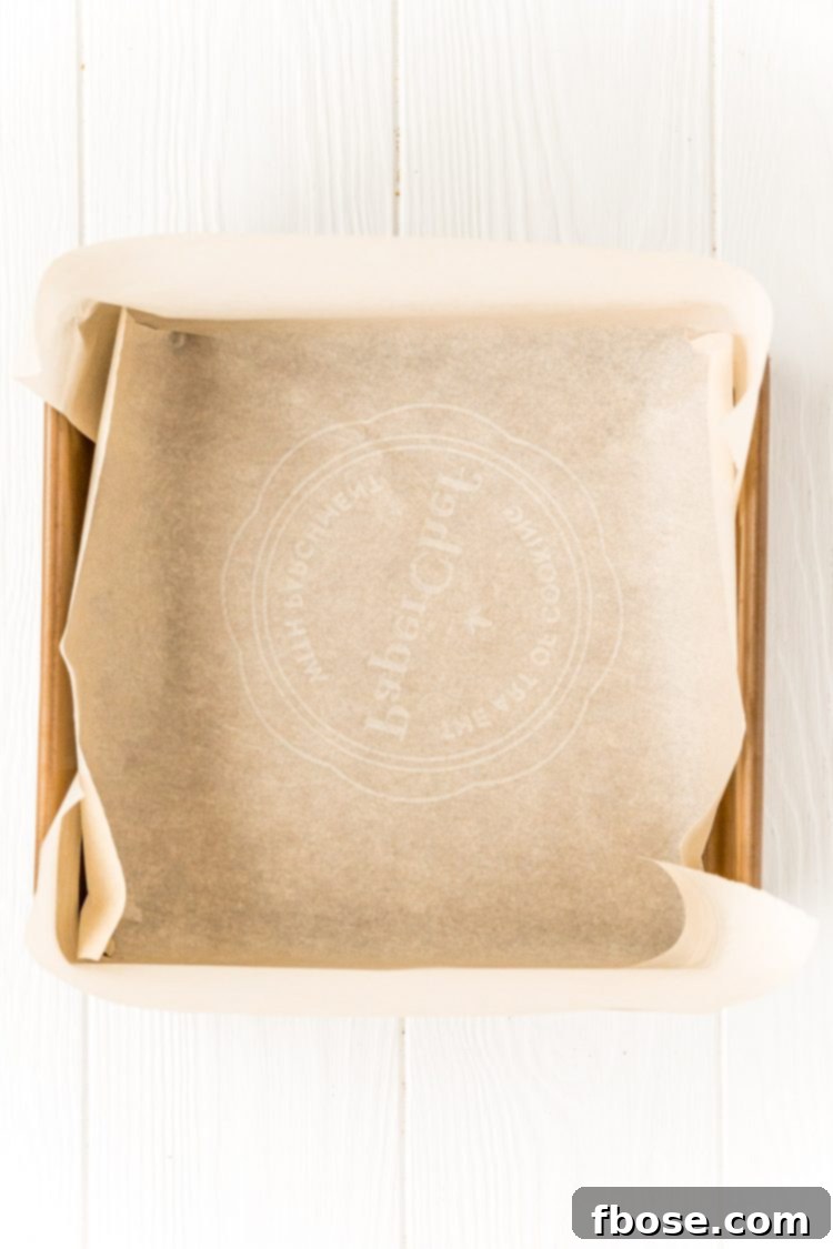 Square baking pan lined with parchment paper.