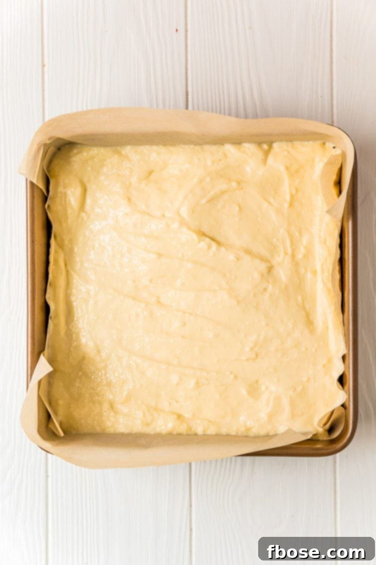 Cheesecake filling in a square baking pan to make cheesecake bars.