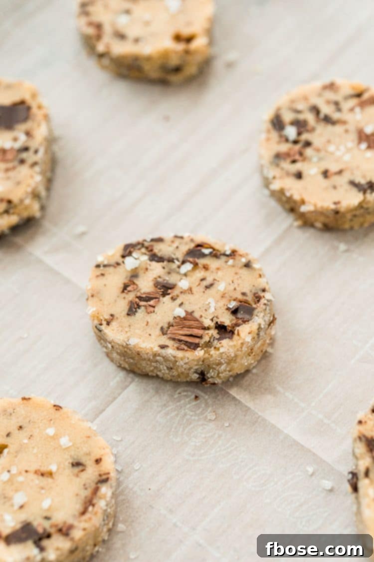 Sliced chocolate chunk cookies on a baking sheet ready to be baked. 