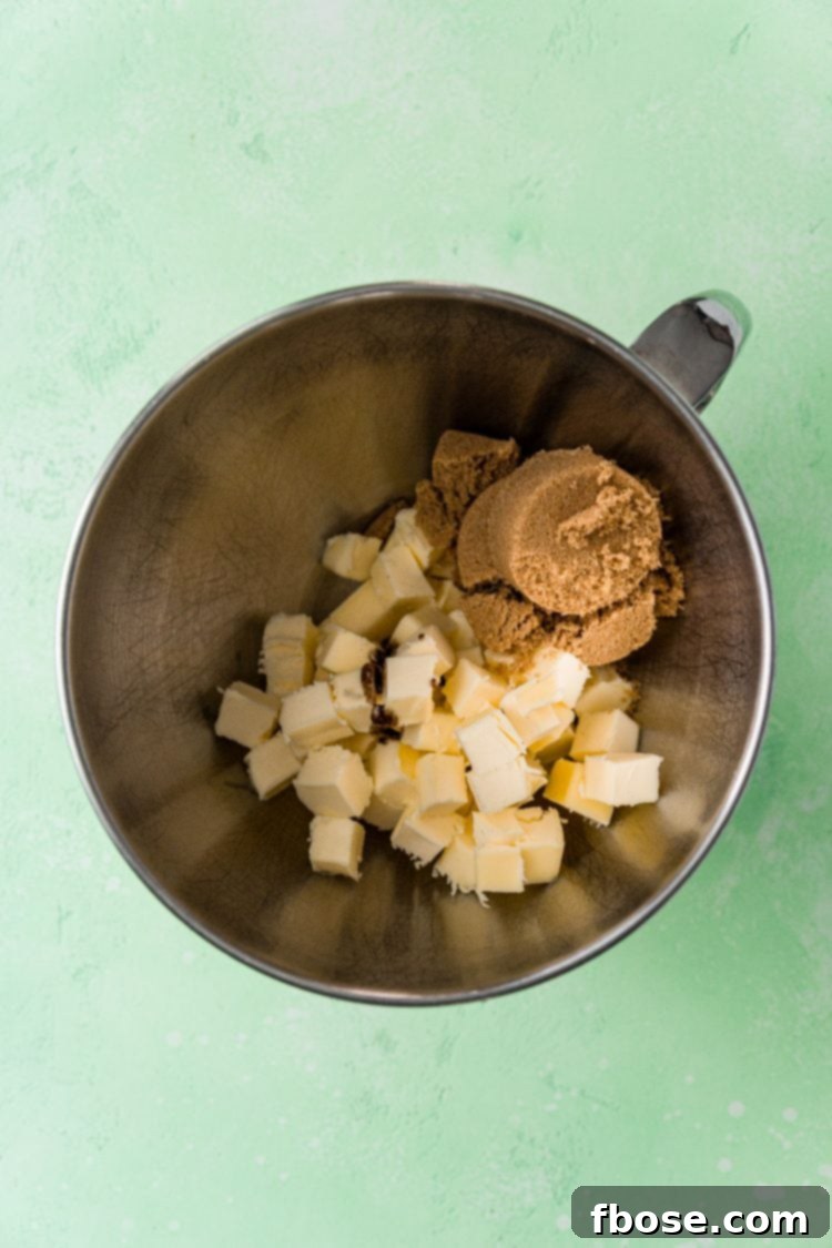 Butter and brown sugar in a metal mixing bowl.