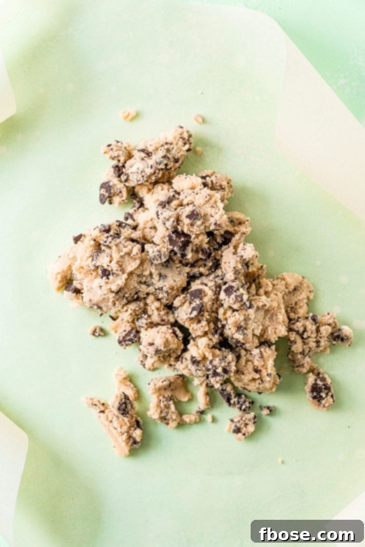 Crumbly cookie dough on parchment paper.