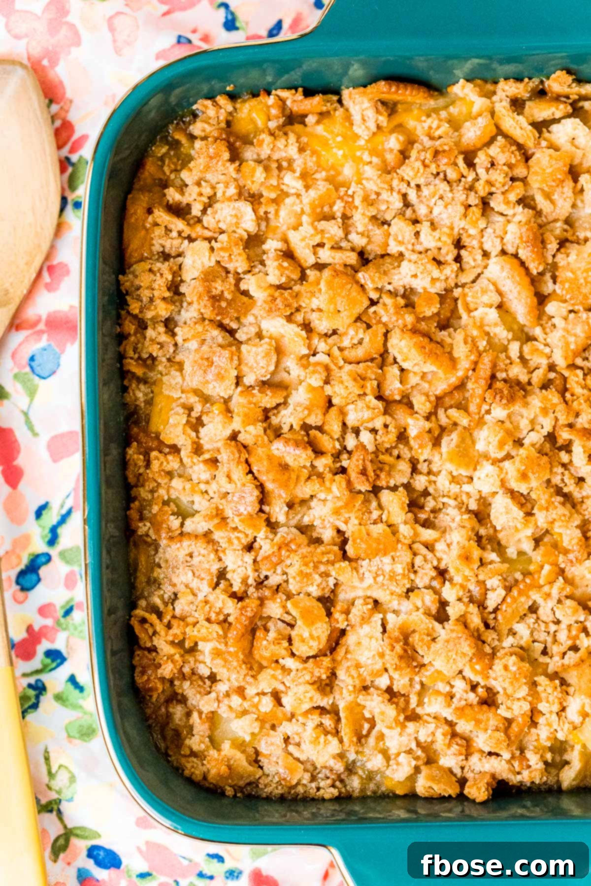 Close up overhead photo of pineapple casserole in a teal baking dish.