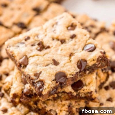 A stack of chocolate chip pan cookies on top of the rest of the pan of cookies.