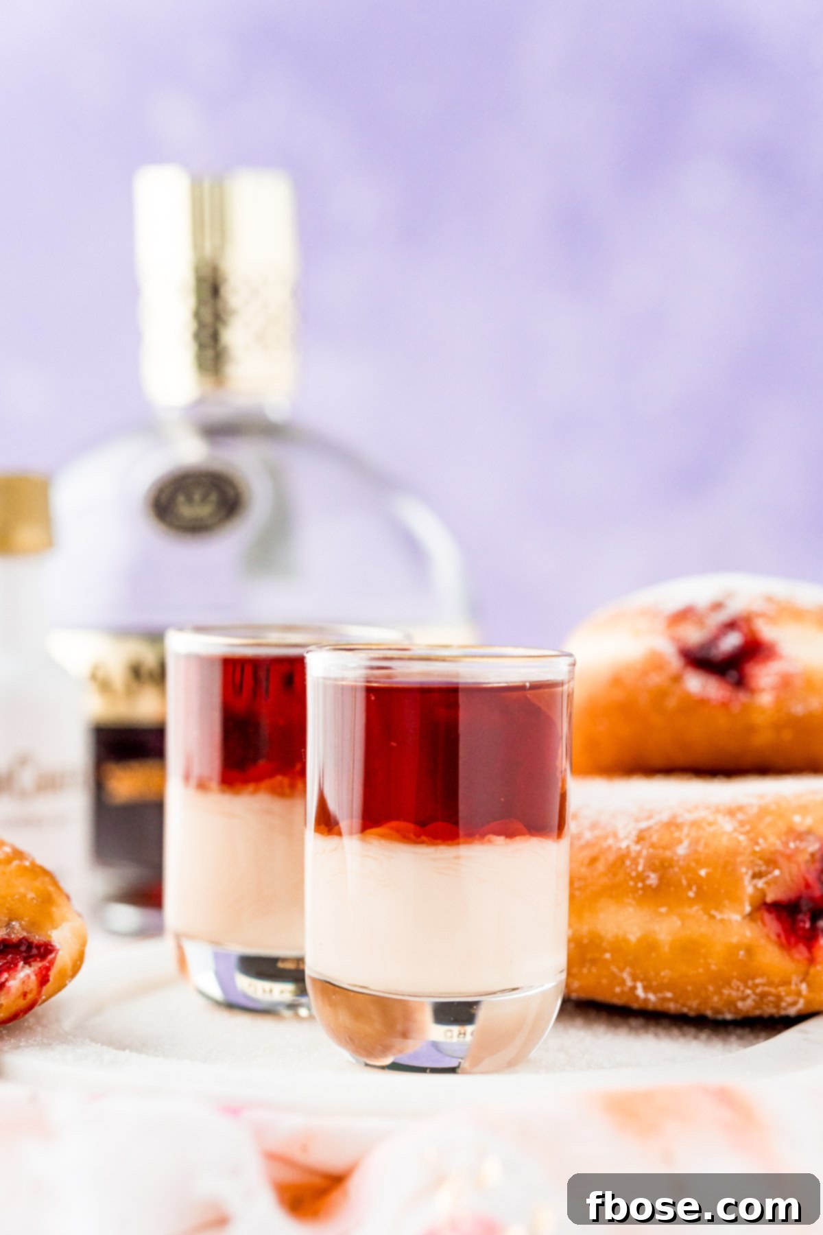 Glazed Jam Shot 4 Jelly donut shots on white serving tray with donuts in the background.