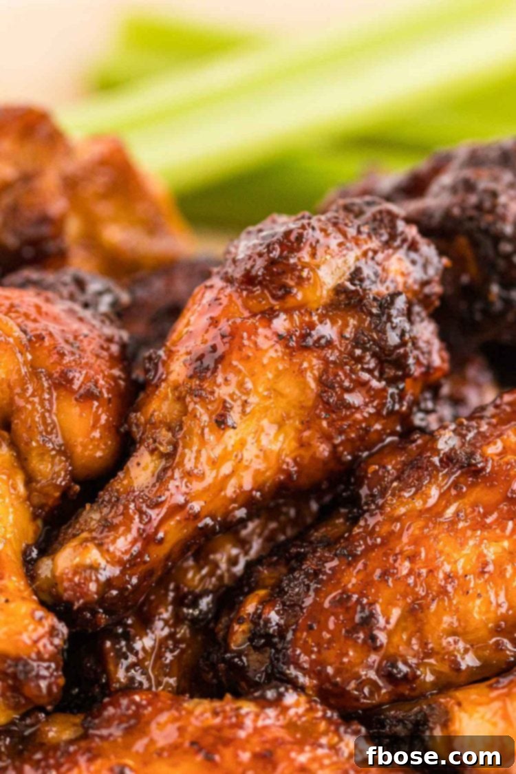 Close up photo of chicken wings with a sticky sauce on them.