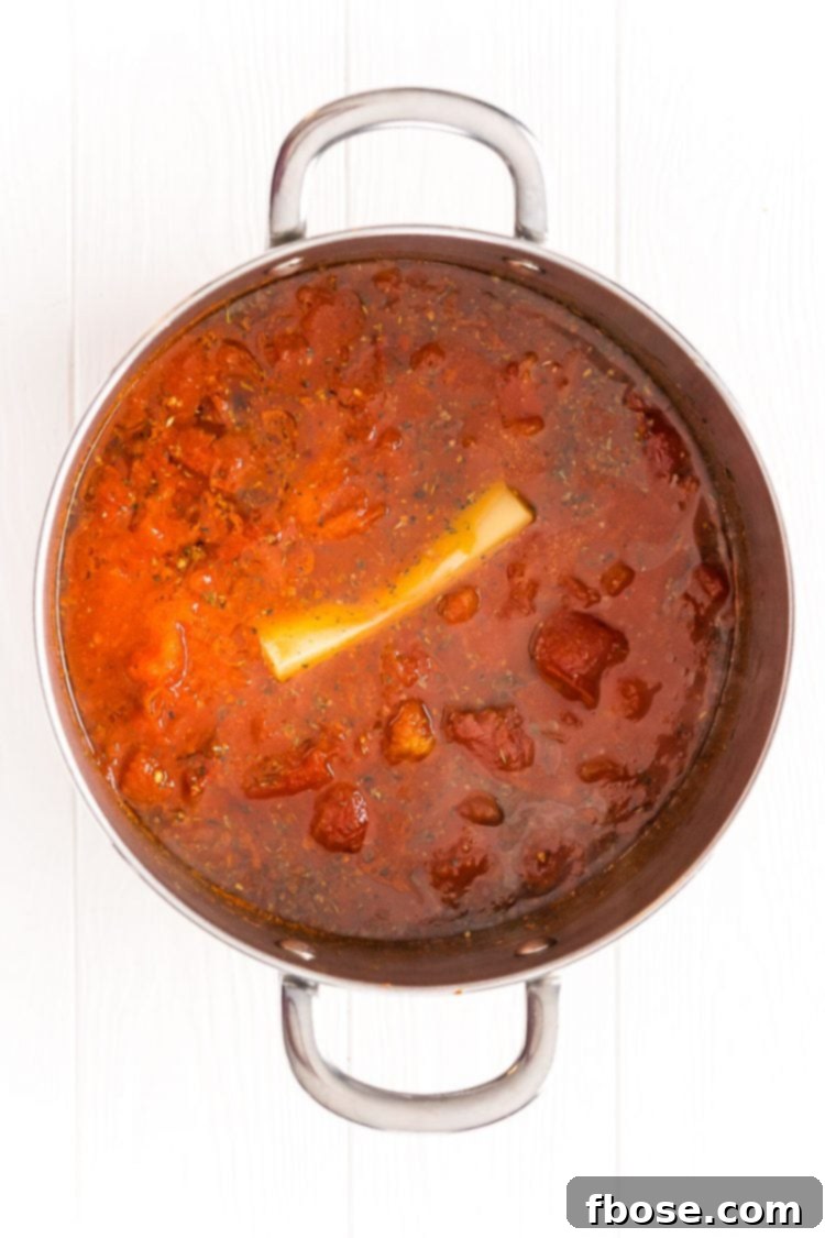 Signature Marinara 6 Marinara sauce in a large pot with a Parmesan rind in it.