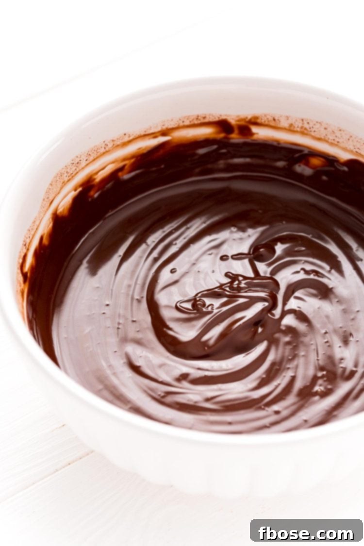 White bowl filled with smooth, dark chocolate ganache, ready to be used.