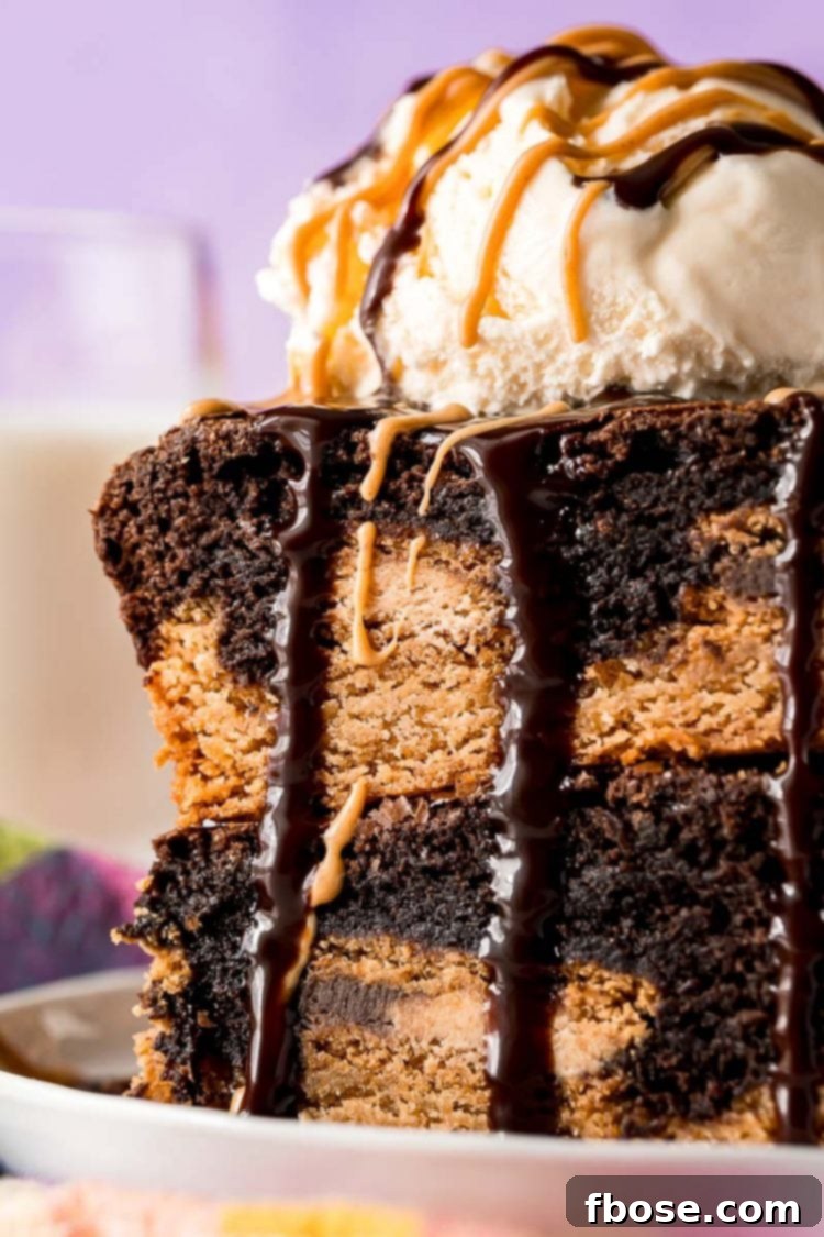 Close-up of two warm Peanut Butter Oreo Brownies stacked, topped with vanilla ice cream and drizzled with chocolate and peanut butter sauces.