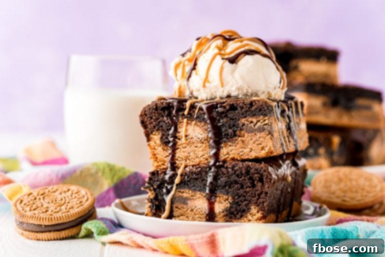 Peanut Butter Oreo Brownies stacked on a white plate with a glass of milk in the background.