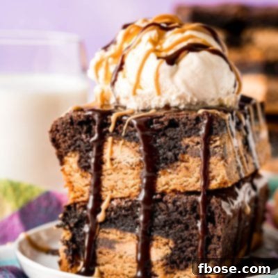Two irresistible Peanut Butter Oreo Brownies stacked, topped with a scoop of vanilla ice cream, and drizzled with luscious peanut butter and hot fudge sauces.
