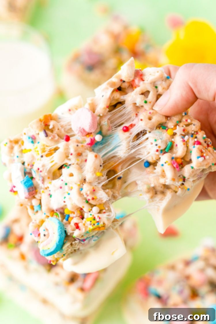 Lucky charms treat being ripped in half showing stretchy gooey marshmallow.