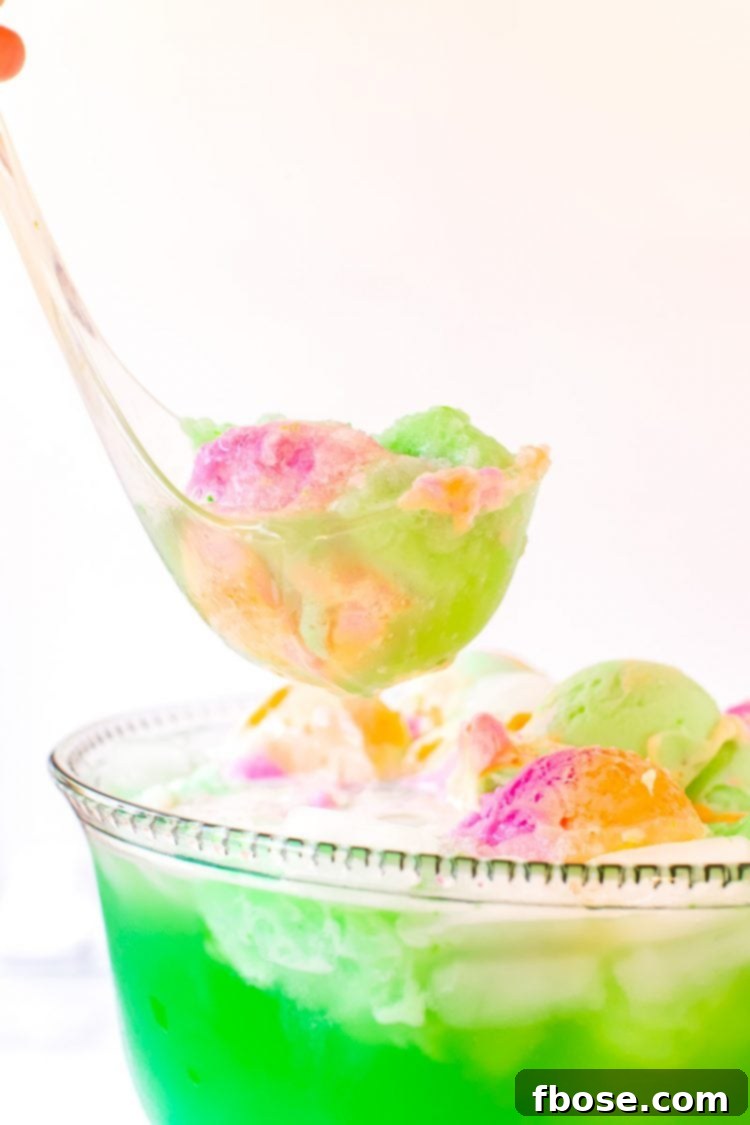 Whimsical Rainbow Sherbet Punch 4 A ladle scooping green punch out of a bowl, showcasing the frothy texture.