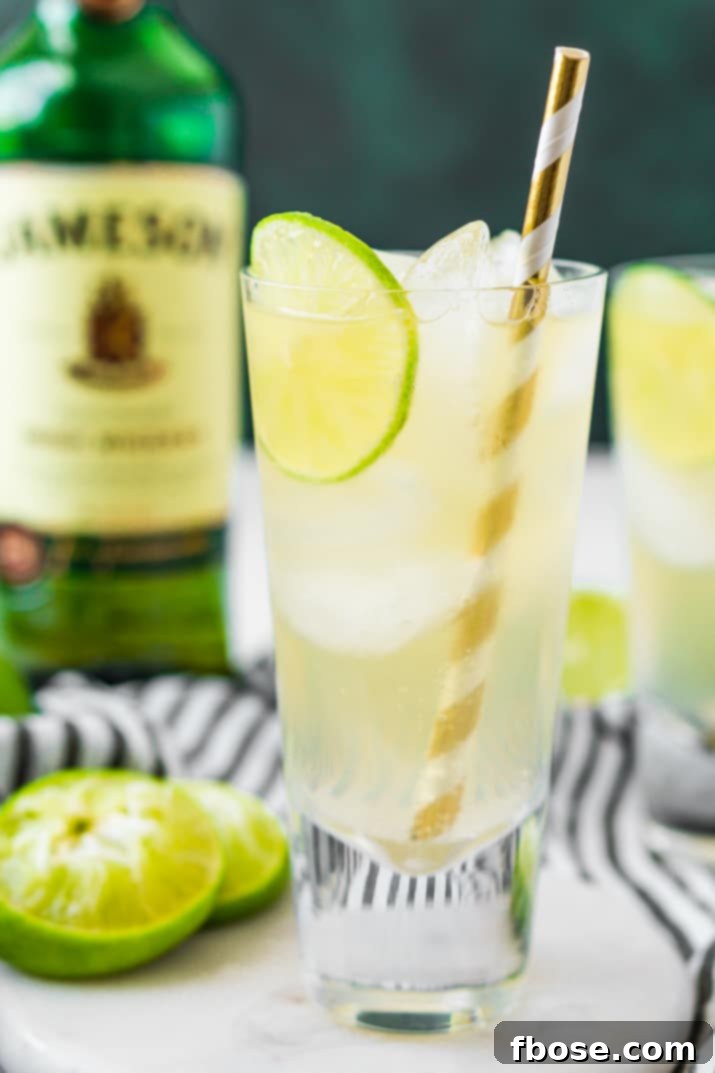 An Irish mule cocktail on a white coaster with a bottle of Jameson in the background.