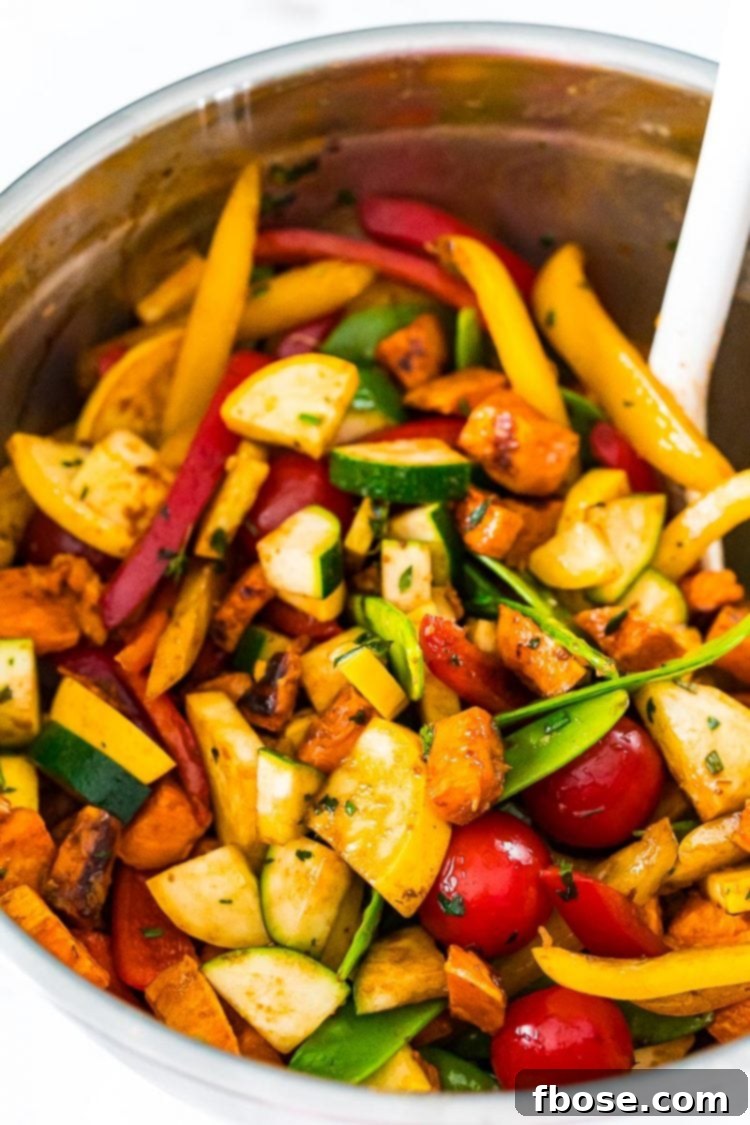 Freshly chopped vegetables being tossed in a large mixing bowl with the herb-infused balsamic dressing, ensuring every piece is evenly coated before roasting.