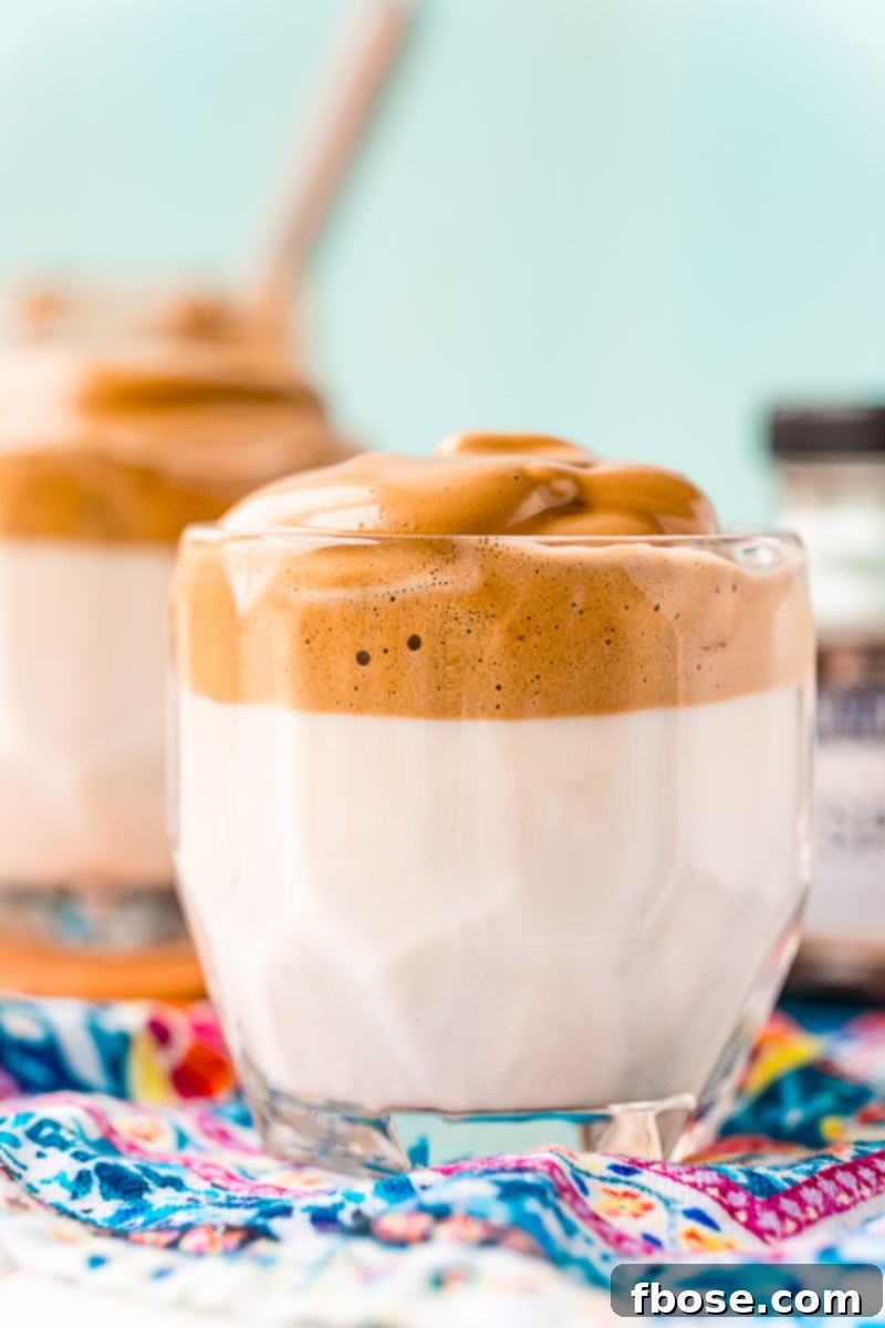 Glass of whipped coffee on a blue patterned napkin.