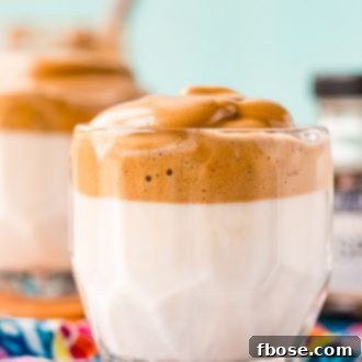 Glass of whipped coffee on a blue patterned napkin.