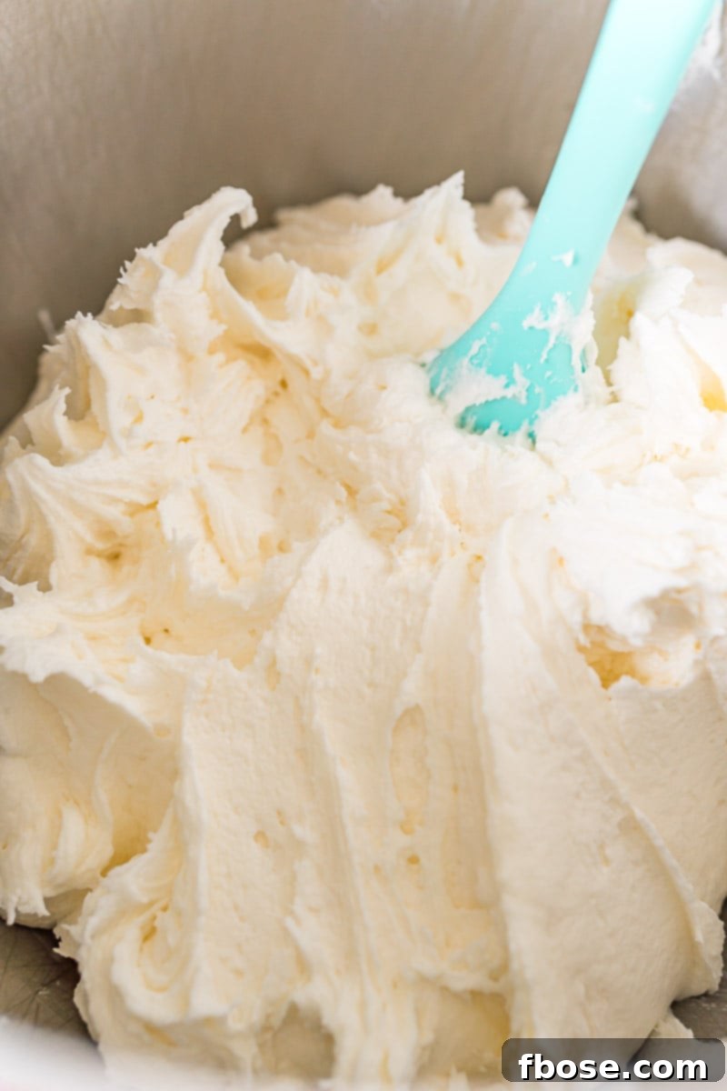 Vanilla cream filling for cream horns being whipped in a stand mixer bowl until fluffy.