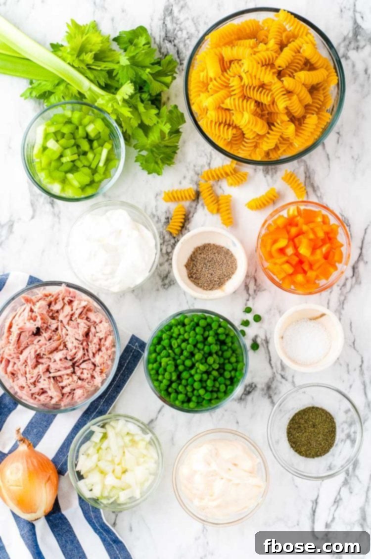Overhead photo of fresh ingredients prepped on a marble surface, ready to make a delicious pasta salad.