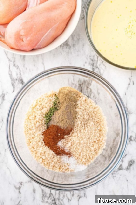 Breadcrumbs and seasonings in a glass prep bowl for breading chicken.