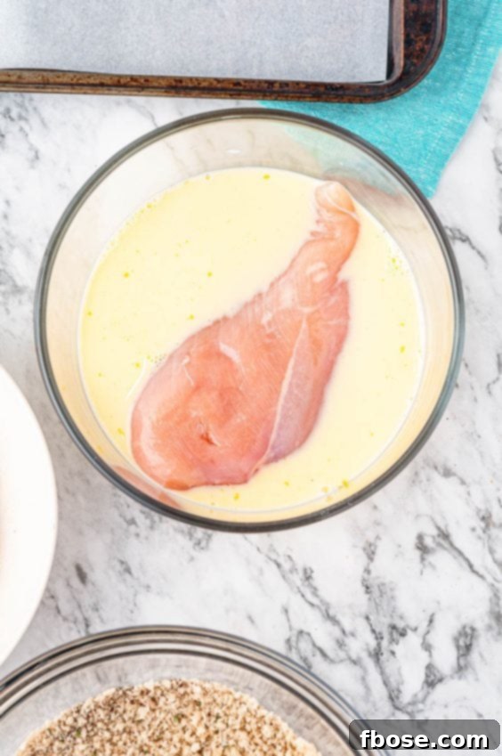Raw Chicken Breast in liquid dip before breading