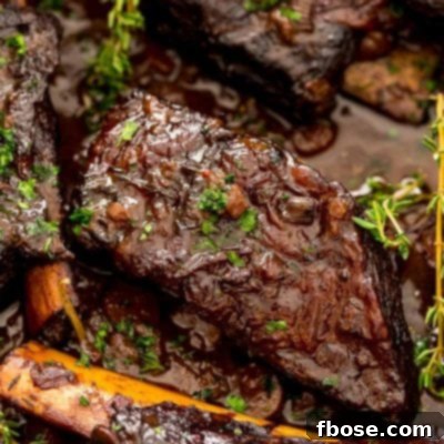 Braised beef short ribs in a pan with sauce.