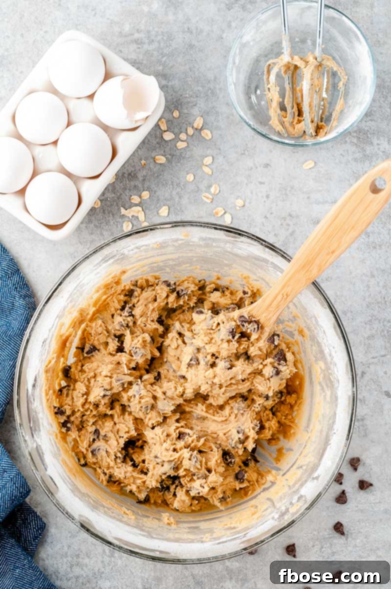 Overhead photo of a bowl of cookie dough on a grey surface.