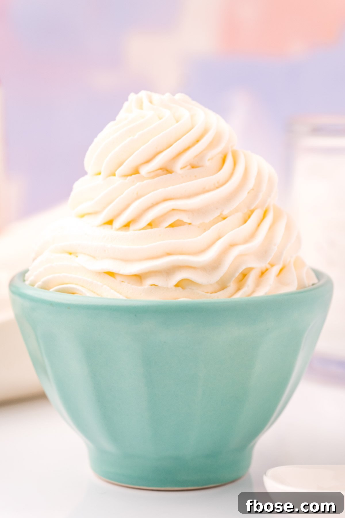 Close up photo of a light blue bowl that has whipped cream piped into it.