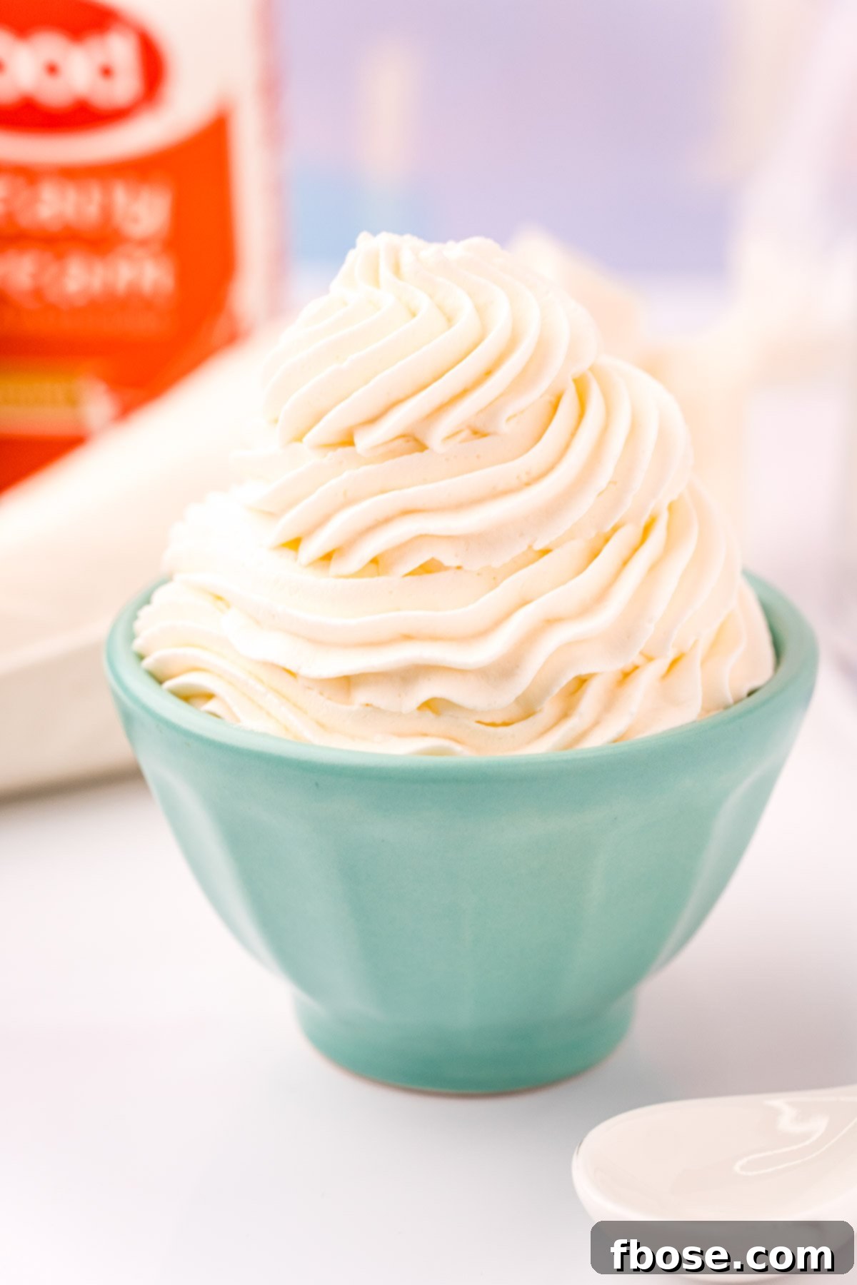 Close up photo of a light blue bowl that has whipped cream piped into it.