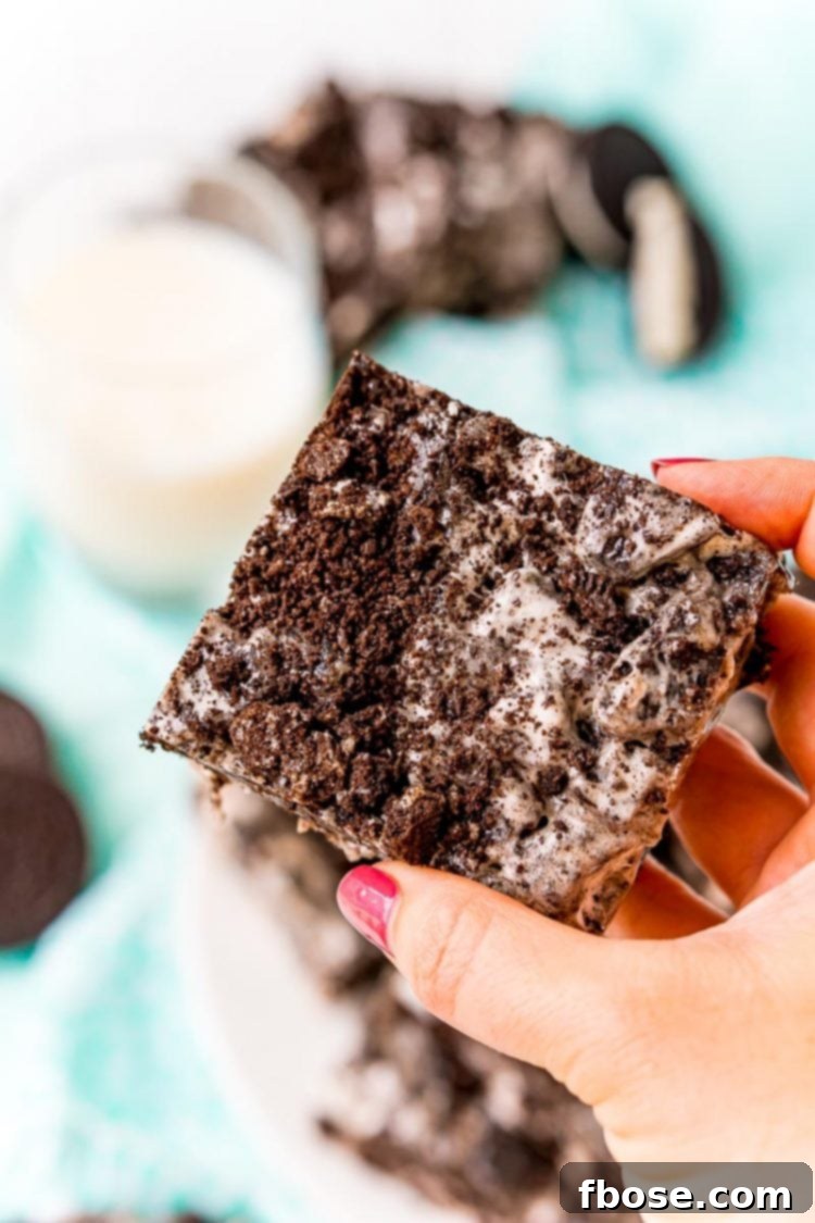 Woman's hand holding an Oreo treat square.