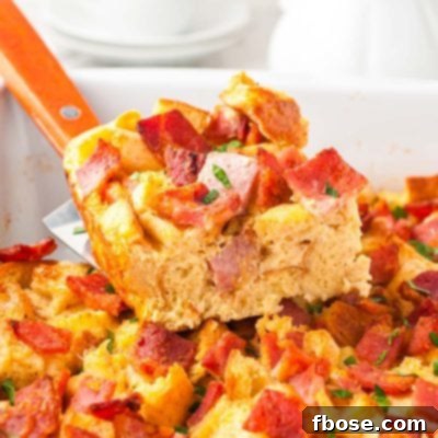 A slice of breakfast casserole being lifted out of a pan.