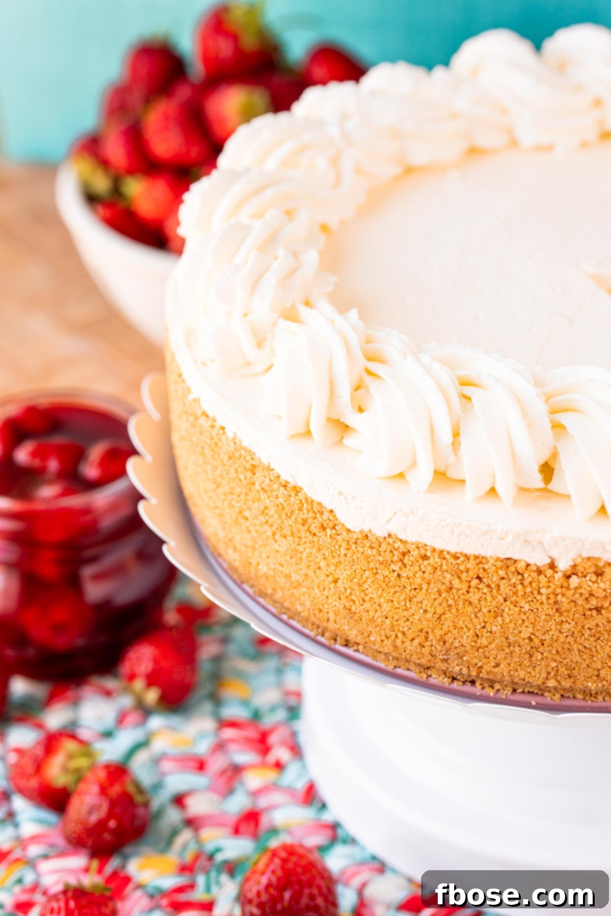 A no bake cheesecake on a white cake stand.