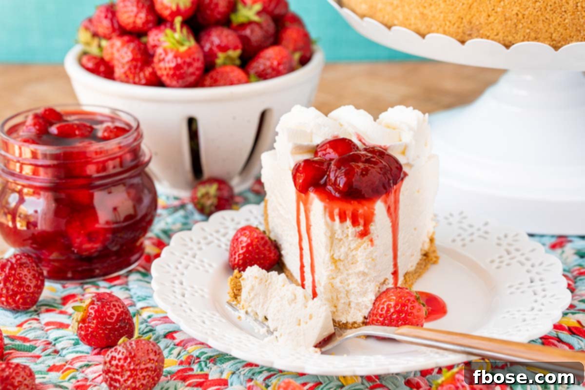 A slice of no bake cheesecake topped with strawberry sauce on a white plate.