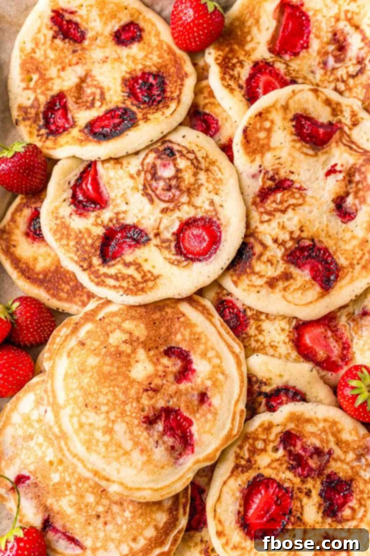 Overhead photo of a baking sheet with strawberry pancakes on it.