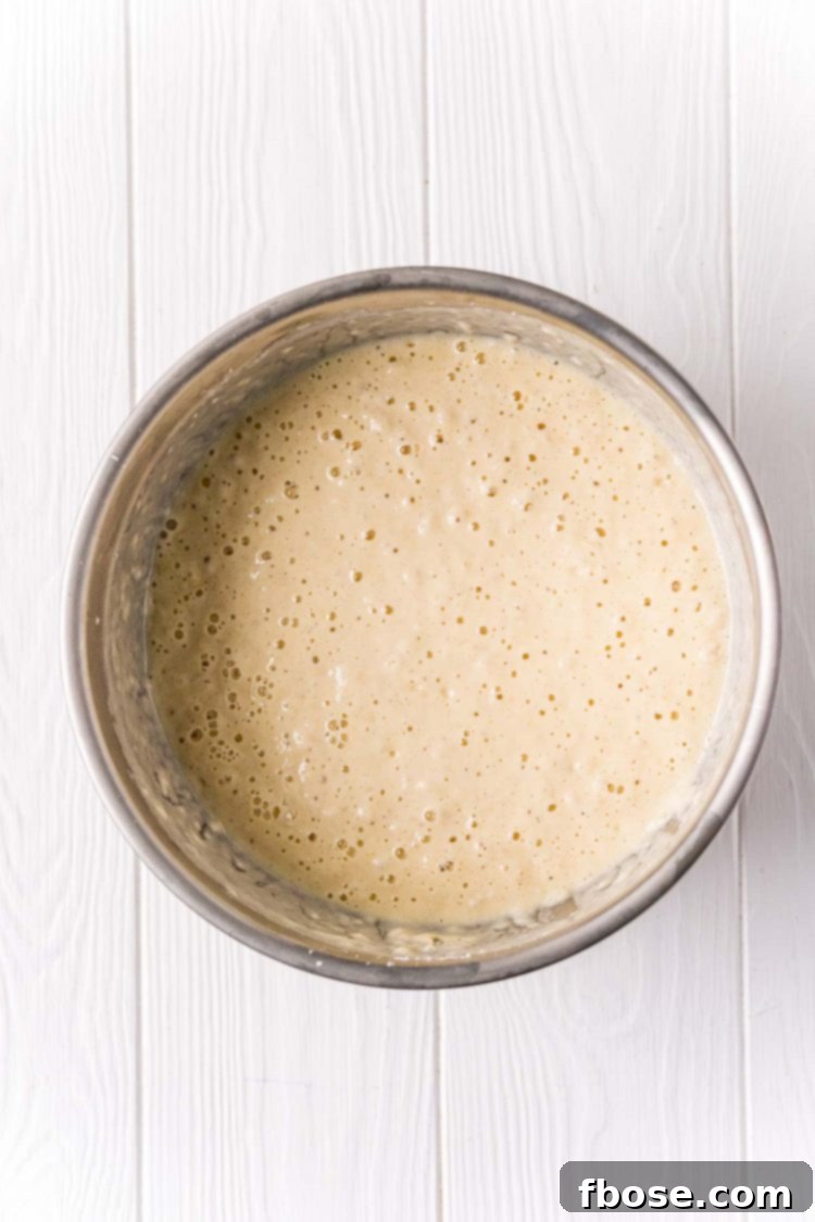 Metal bowl filling with pancake batter.