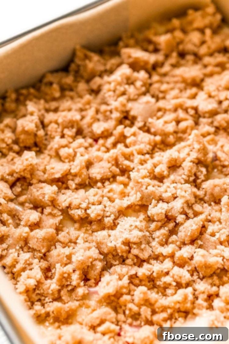 Coffee cake ready to be baked in a parchment paper lined baking pan.
