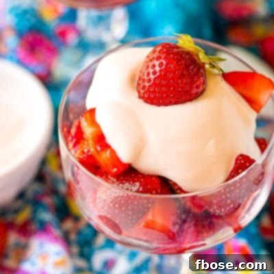 Close up photo of Strawberries Romanoff in a glass stemmed dish on a blue napkin.