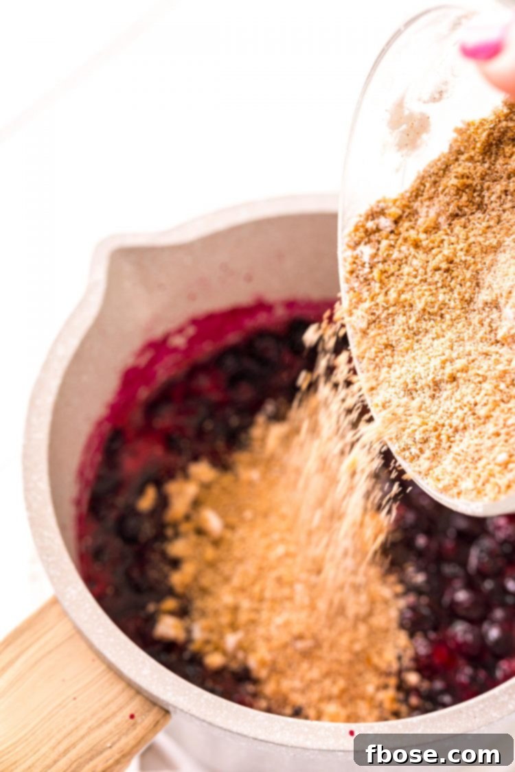 Ultimate Blueberry Cheesecake Bars 6 spices being added to a pot of simmering blueberries.