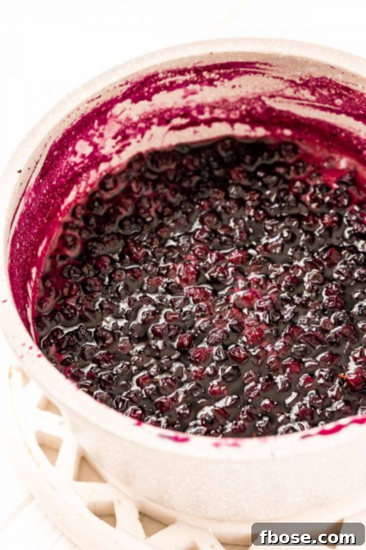 Blueberry Bliss Syrup 4 Blueberries, sugar, and water simmering in a small saucepan, actively cooking to make simple syrup.