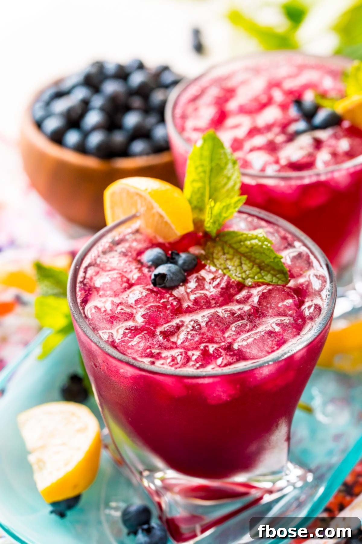 Close up photo of a glass filled with a blueberry cocktail.