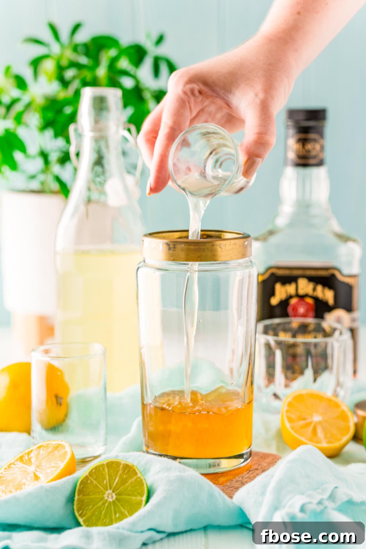 Crafting the Perfect Bourbon Sour 5 Sweet and sour mix being added to a cocktail shaker.