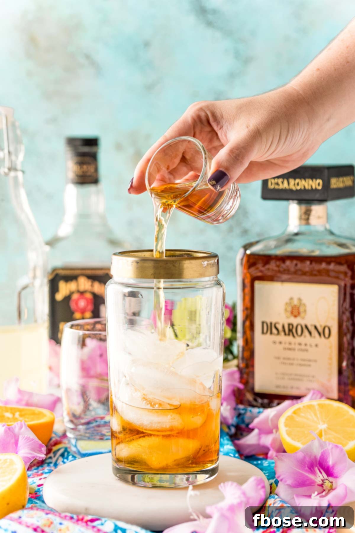 Bourbon being added to a cocktail shaker.