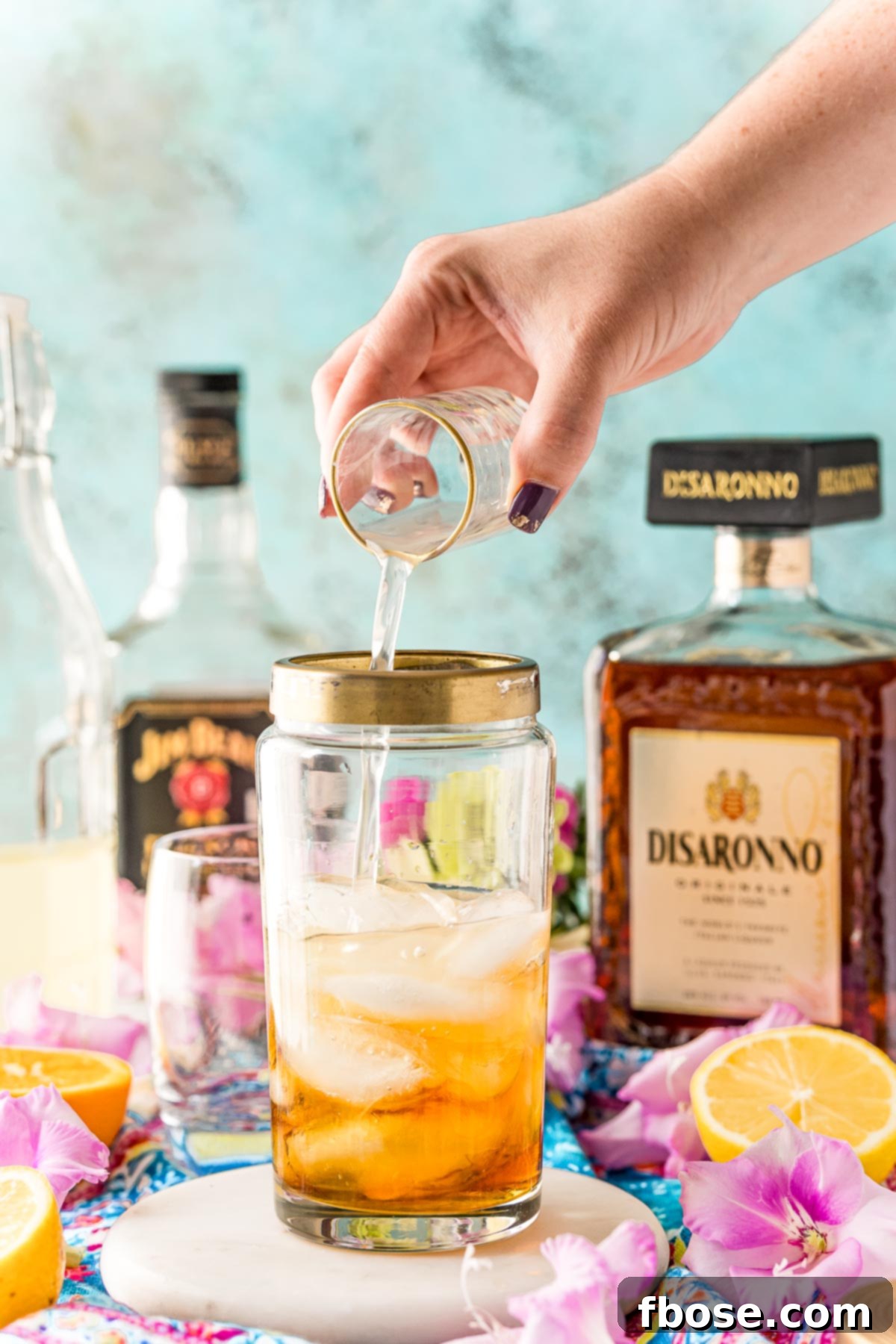 Sour mix being added to a cocktail shaker.