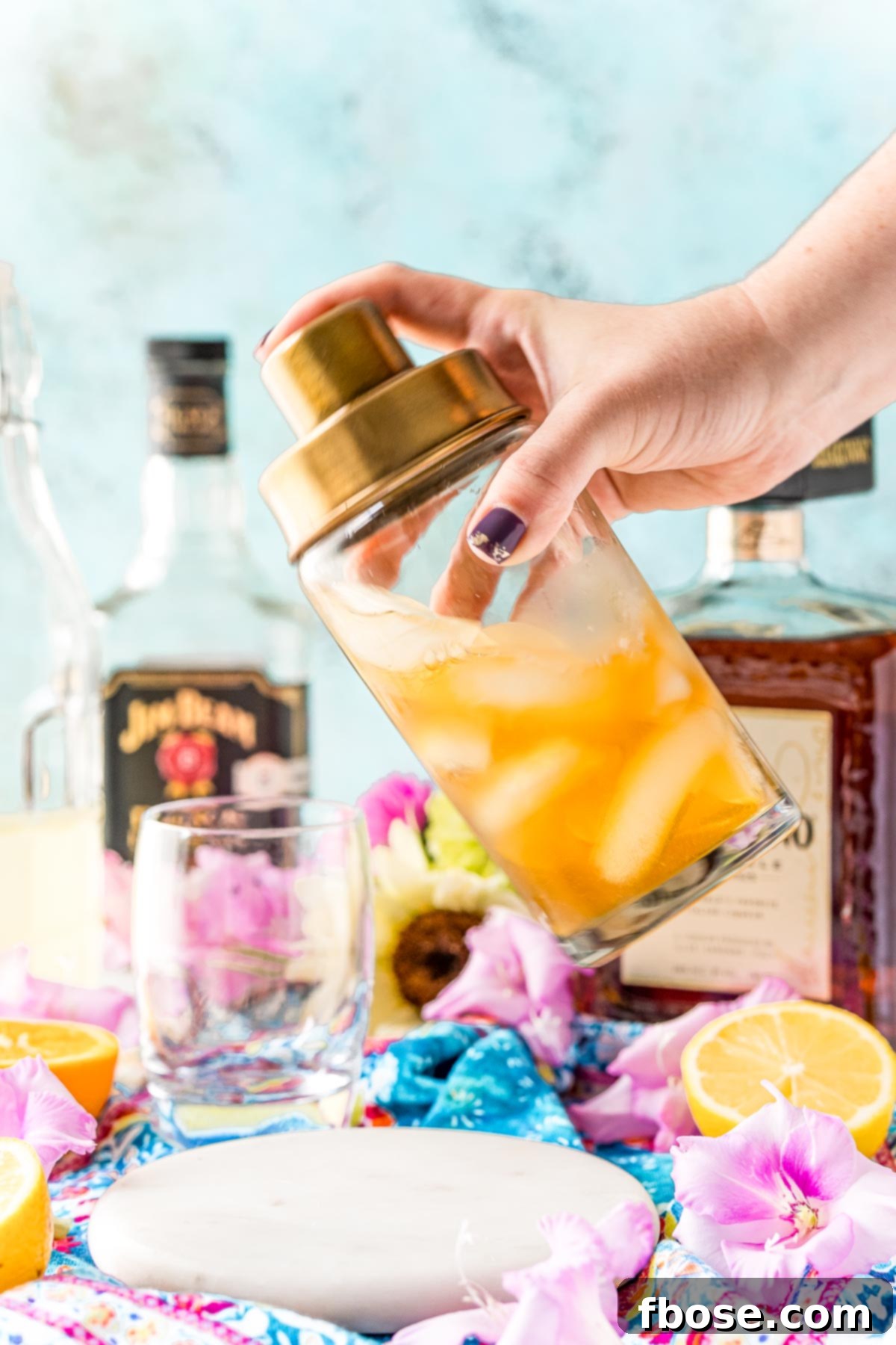 A cocktail shaker being shaken to make an Amaretto sour.