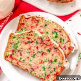 two slices of christmas quick bread on a white plate.