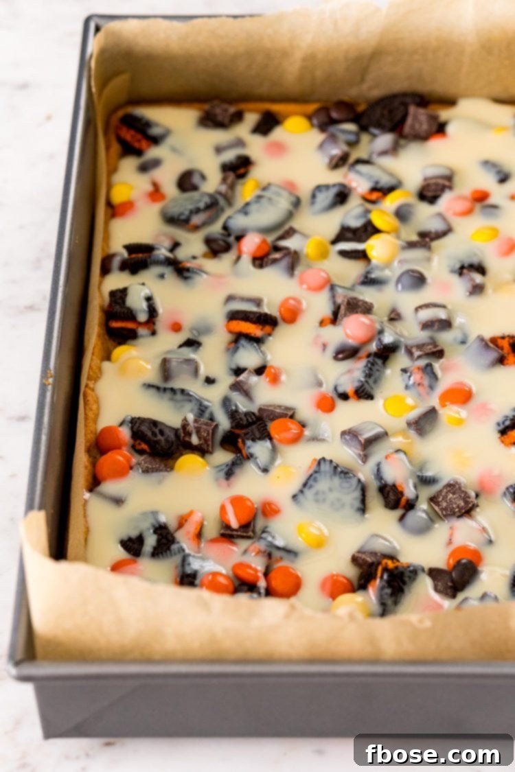 Spellbound Seven-Layer Bars 5 Sweetened condensed milk drizzled over the top of cookies bars topped with candy.