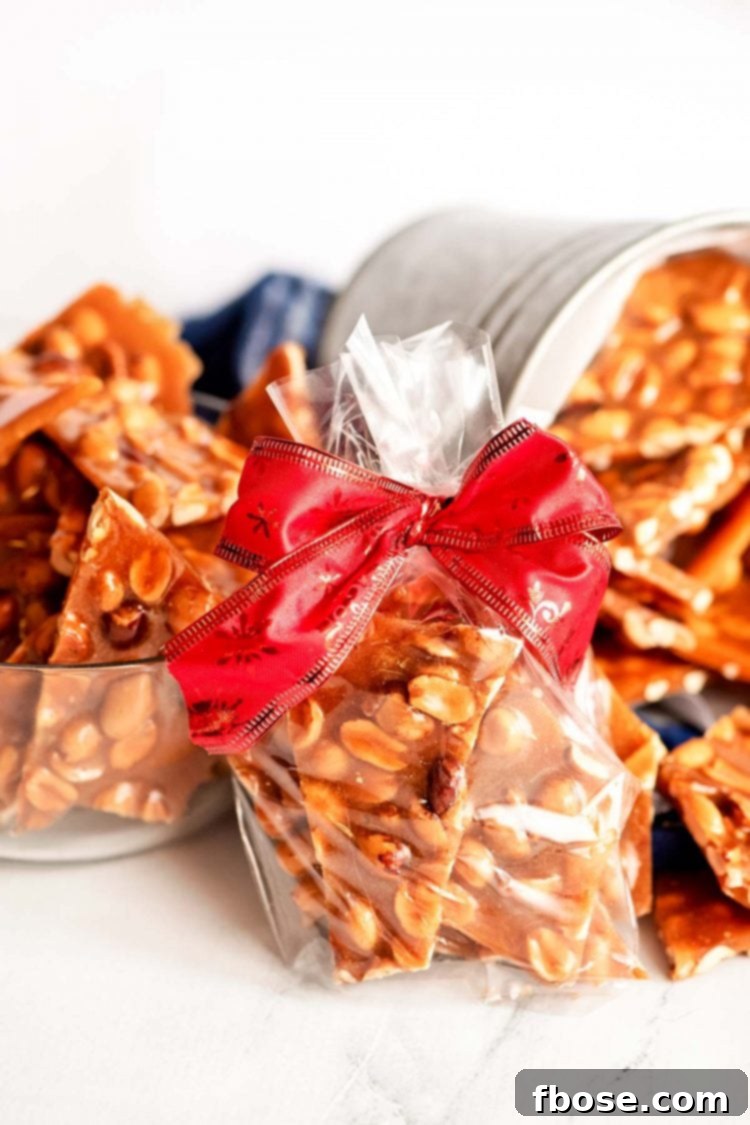 Peanut brittle wrapped up in a cello bag with red ribbon.
